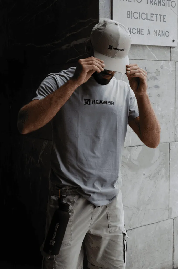Borraccia HEAWEN nera portata a mano da un ragazzo in t-shirt HEAWEN